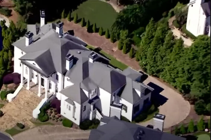 Aerial view of a $1.7M mansion surrounded by trees and landscaping linked to dentist’s rampage incident.