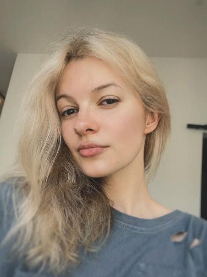 Young woman with blonde hair and a neutral expression wearing a worn gray shirt, related to GoFundMe fundraising pages removal.
