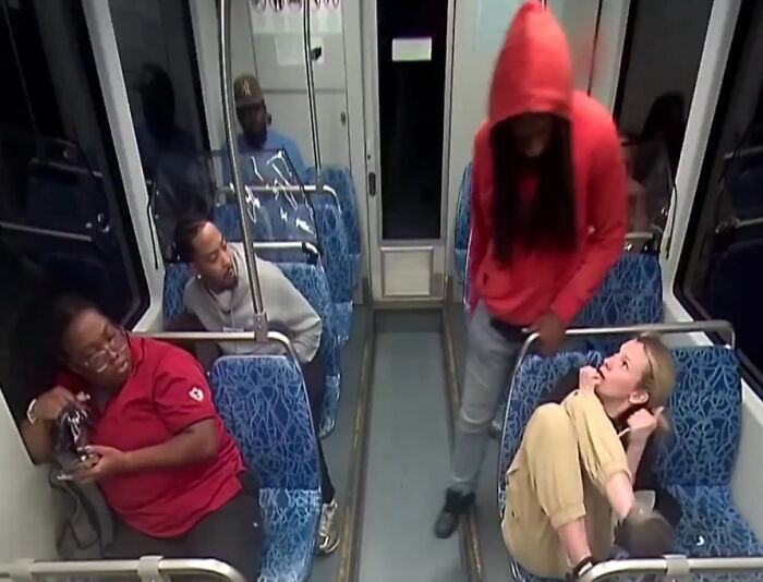 Ukrainian refugee on train showing fear and horror after being stabbed, with other passengers seated nearby. Ukrainian refugee on train showing fear and horror after being stabbed, with other passengers seated nearby.