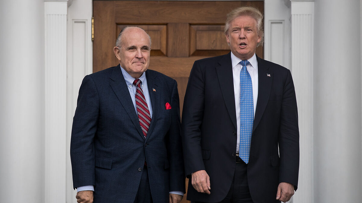 Rudy Giuliani and Donald Trump standing outdoors in suits, related to Presidential Medal of Freedom announcement.