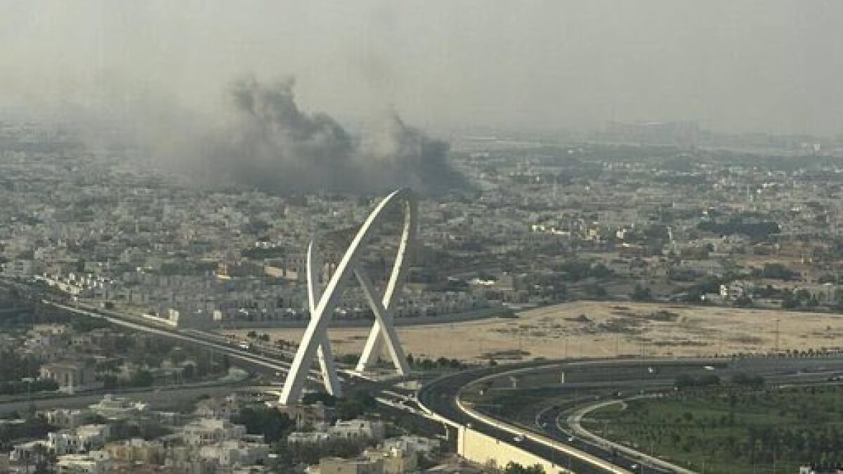 Smoke rising over Qataru2019s capital city skyline following attack linked to Israel targeting Hamas leaders.