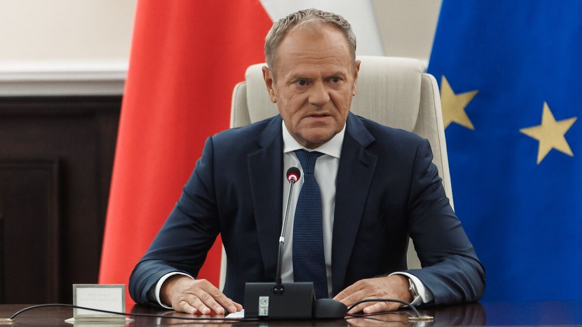 Polish official speaking at a conference with Poland and European Union flags in the background discussing drone defense.