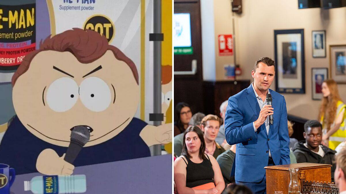 South Park cartoon character holding microphone next to man in blue suit speaking at public event.
