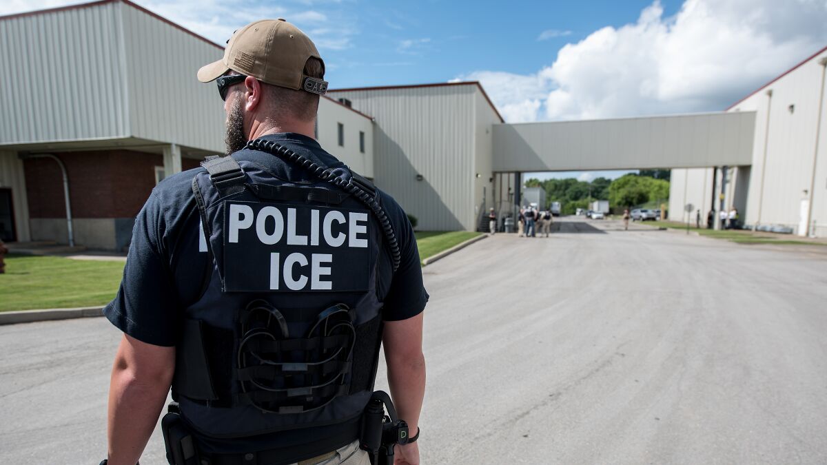 ICE police officer in tactical gear standing outside a secured facility in Texas amid multiple injuries and fatalities report.