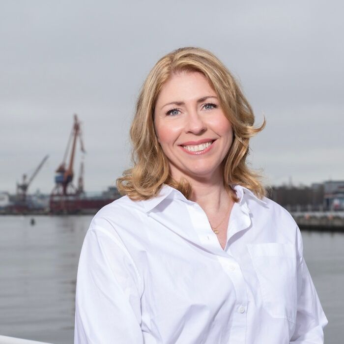 Sweden’s new health minister smiling outdoors near a harbor on her first day at work before collapsing on live TV.