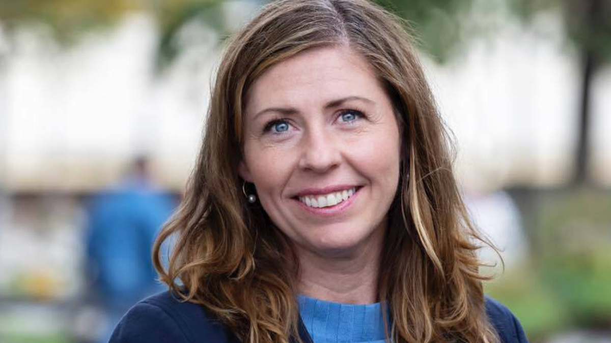 Swedenu2019s new health minister smiling outdoors with blurred trees and people in the background on her first day at work