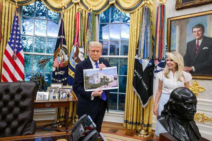 Donald Trump in the Oval Office holding a photo, related to agency oversight of controversial D.C. renovations. Donald Trump in the Oval Office holding a photo, related to agency oversight of controversial D.C. renovations.