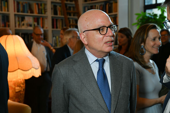 Michael Wolff in a gray suit and blue tie at a social event, related to Trump biographer lawsuit and Epstein case. Michael Wolff in a gray suit and blue tie at a social event, related to Trump biographer lawsuit and Epstein case.