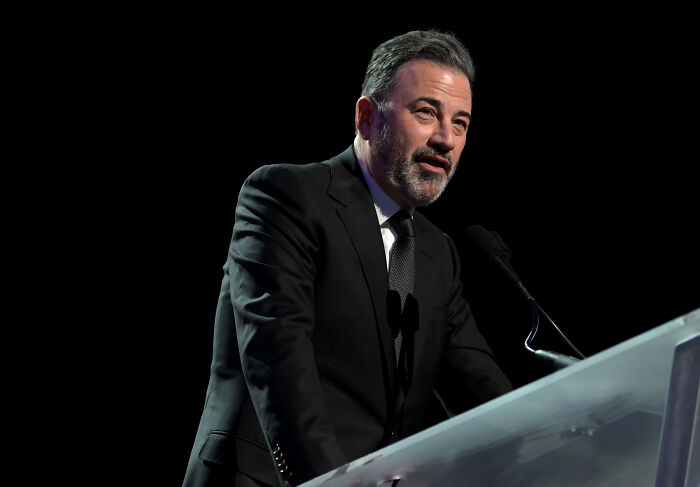 Man in a dark suit speaking at a podium against a black background, related to Musk joins Netflix boycott pro-trans cartoon.