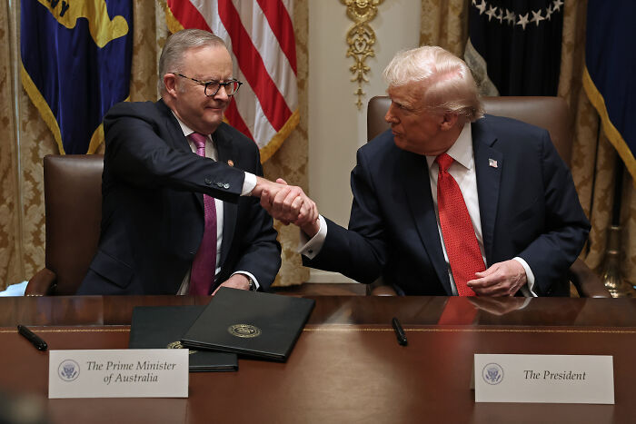 Donald Trump shaking hands with the Prime Minister of Australia during a White House meeting, reacting to being called nuts.