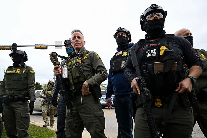 Federal agents in tactical gear armed and standing alert during government shutdown enforcement efforts. Federal agents in tactical gear armed and standing alert during government shutdown enforcement efforts.