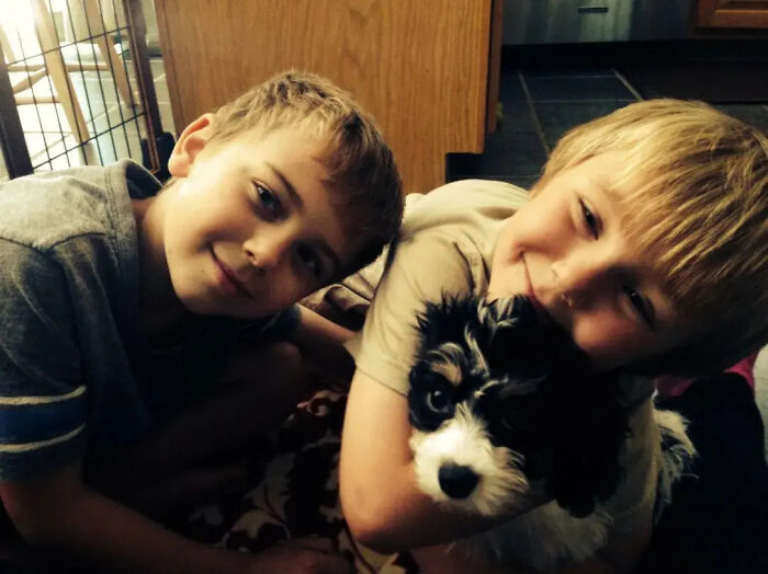 Two young boys smiling and holding a small black and white dog, illustrating Florida man family tragedy keywords. Two young boys smiling and holding a small black and white dog, illustrating Florida man family tragedy keywords.