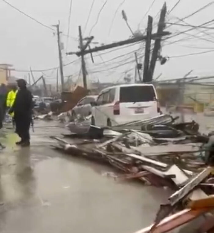 Debris and damaged vehicles line a flooded street as Hurricane Melissa causes devastation across Jamaica. Debris and damaged vehicles line a flooded street as Hurricane Melissa causes devastation across Jamaica.