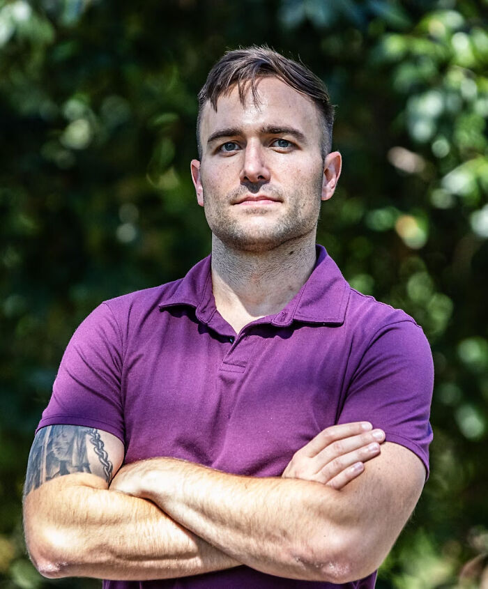 National Guard troop standing outdoors with arms crossed, determined expression, defying Chicago deployment order. National Guard troop standing outdoors with arms crossed, determined expression, defying Chicago deployment order.