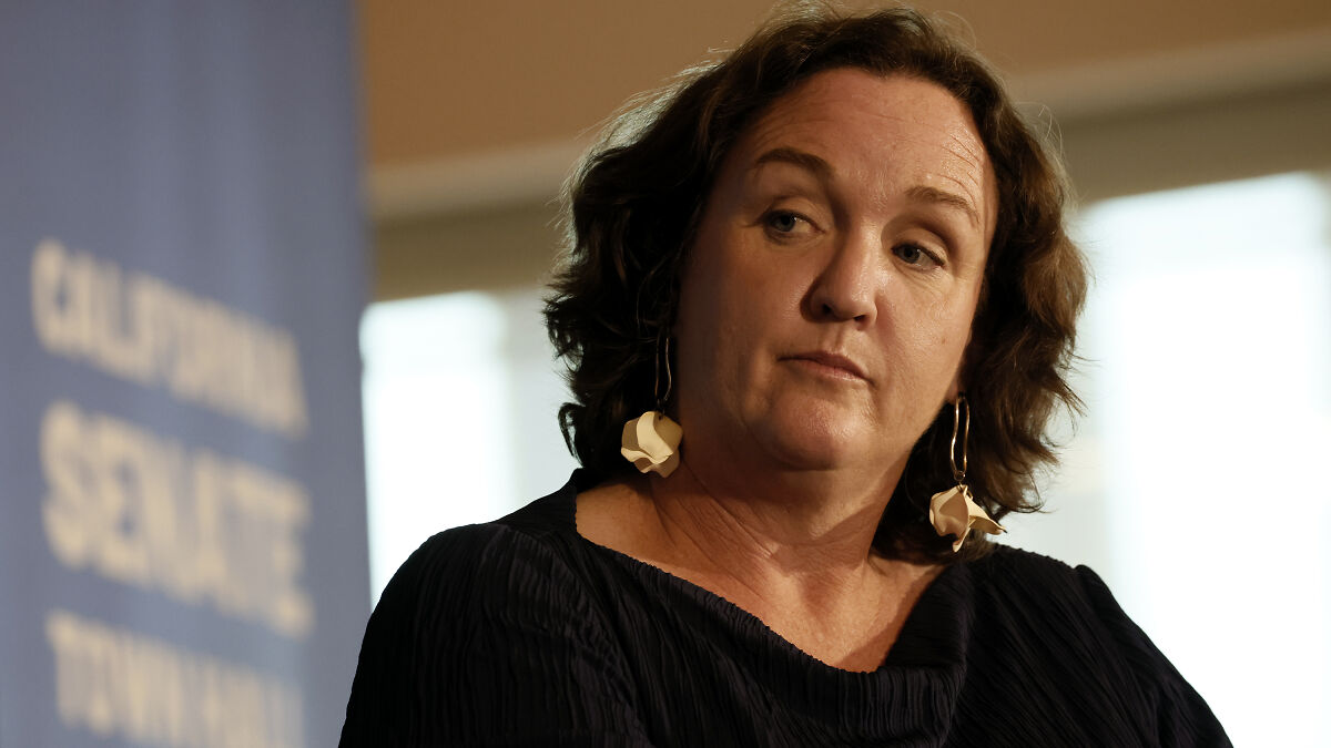 California governor hopeful Katie Porter wearing flower earrings and a black top during a public speaking event.