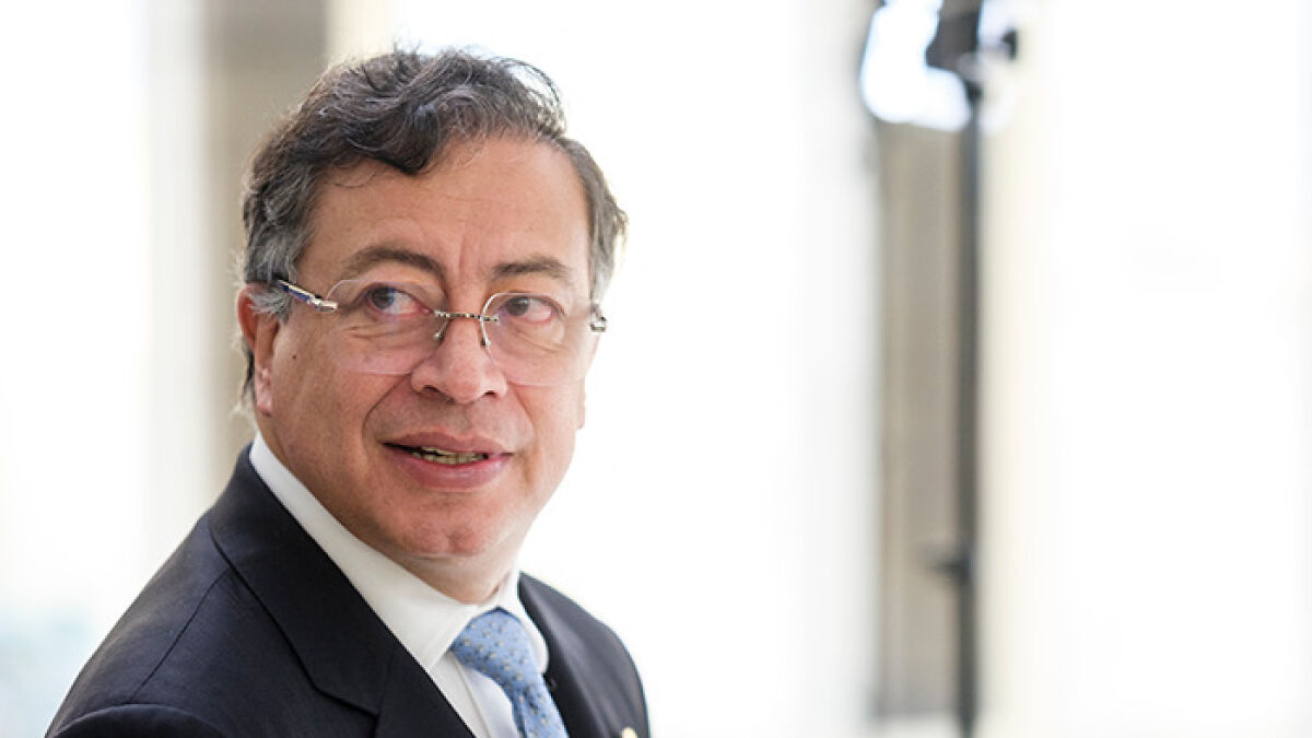 Colombiau2019s president in a suit and glasses looking aside, highlighting his role amid Trumpu2019s Venezuela threats.