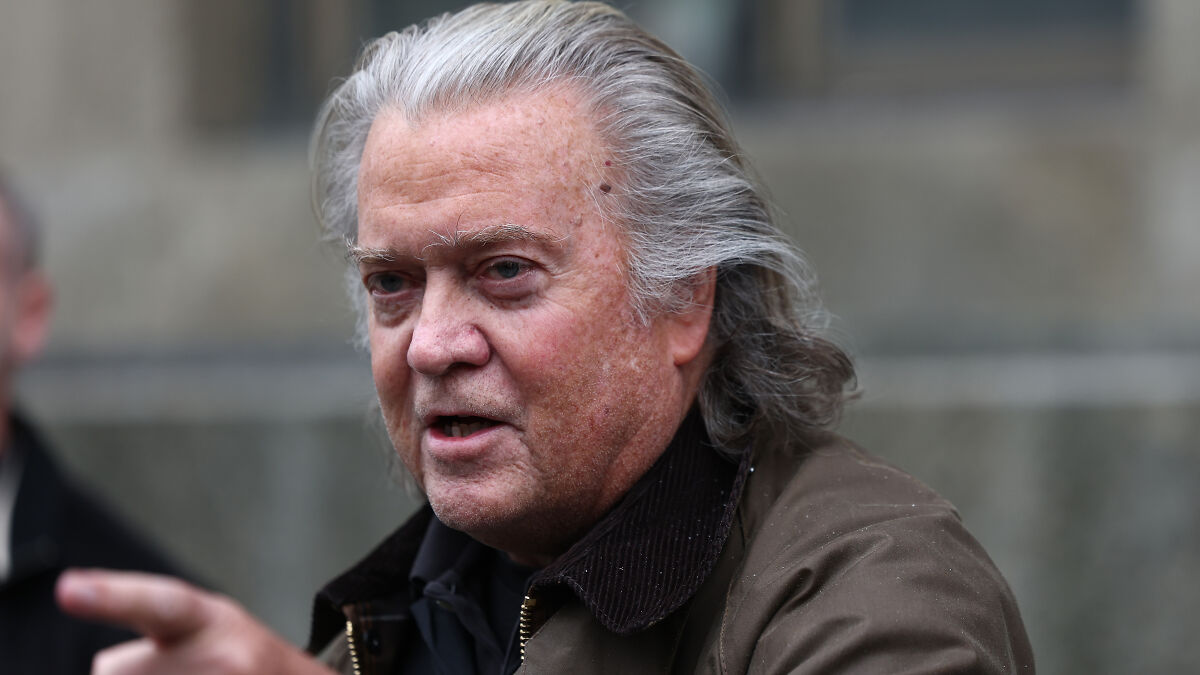 Steve Bannon speaking outdoors, wearing a dark jacket, discussing strategy for a third Trump term and divine will.