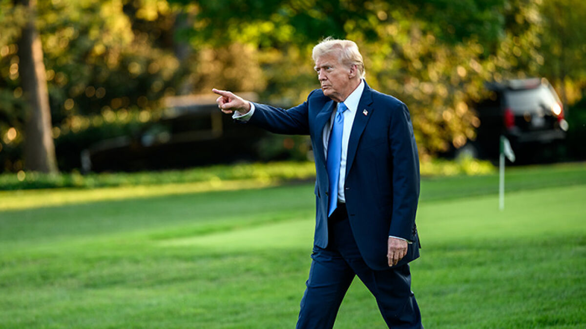 Donald Trump walking on grass, wearing a suit and pointing, related to Trumpu2019s $40 billion Argentina deal topic.
