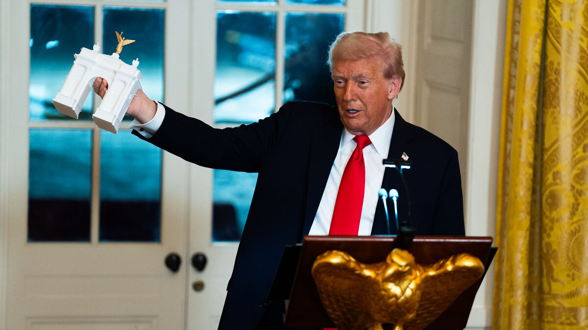 Donald Trump holding a small White House model during a costly White House renovation project presentation.