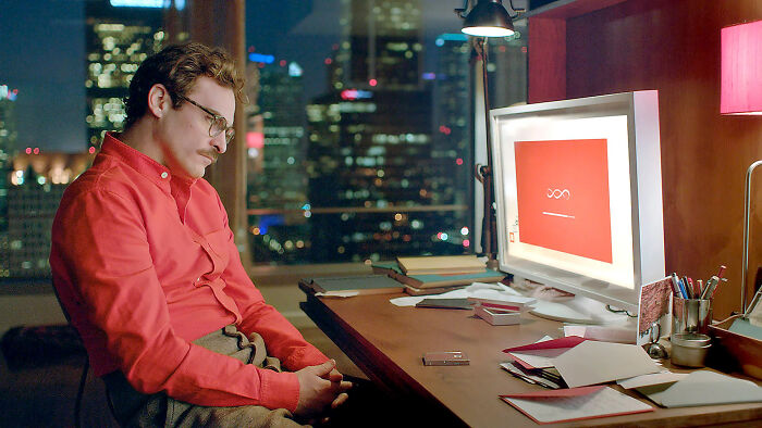 Man in a red shirt sitting at a desk with a computer, reflecting the internet’s struggle to handle ChatGPT vibes. Man in a red shirt sitting at a desk with a computer, reflecting the internet’s struggle to handle ChatGPT vibes.