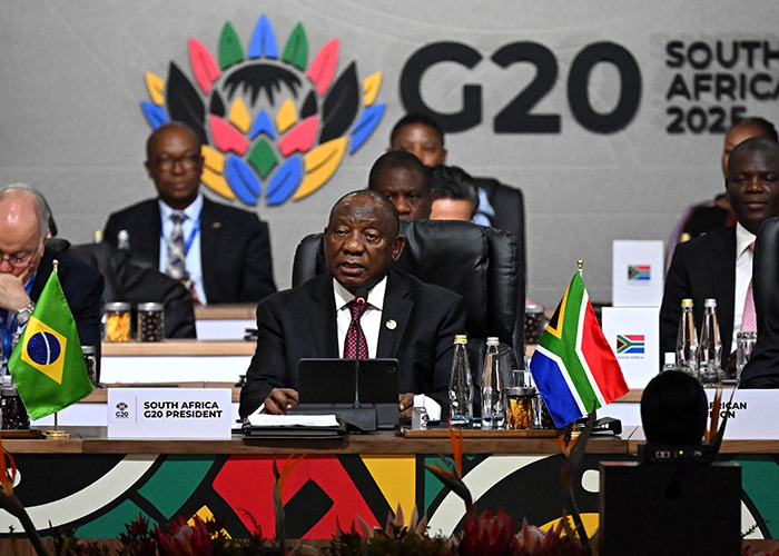 South Africa G20 President speaking at the summit, with flags and delegates discussing new energy and global cooperation. South Africa G20 President speaking at the summit, with flags and delegates discussing new energy and global cooperation.