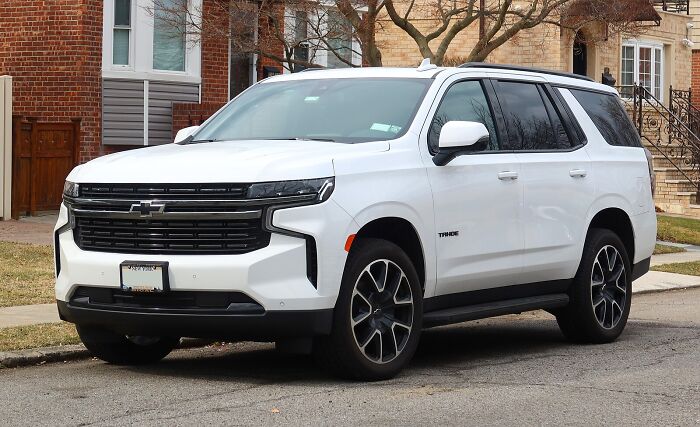 White Chevrolet Tahoe SUV parked on a residential street related to federal agent texted she had seven holes shooting case. White Chevrolet Tahoe SUV parked on a residential street related to federal agent texted she had seven holes shooting case.