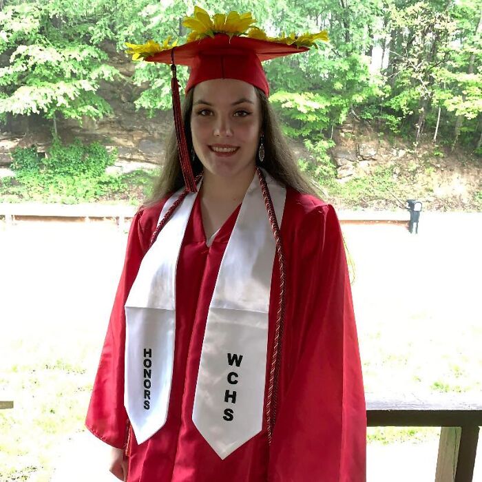 Young woman in red graduation gown and cap with sunflowers, representing honor and achievement linked to National Guard member news. Young woman in red graduation gown and cap with sunflowers, representing honor and achievement linked to National Guard member news.