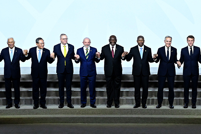 World leaders at G20 summit holding hands on stage, symbolizing unity and new energy collaboration efforts. World leaders at G20 summit holding hands on stage, symbolizing unity and new energy collaboration efforts.