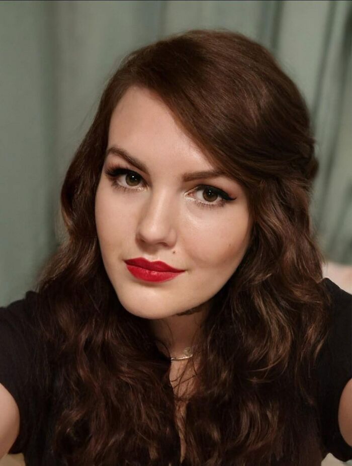 Young woman with long curly brown hair and red lipstick, related to the homicide of British woman in the U.S. case.