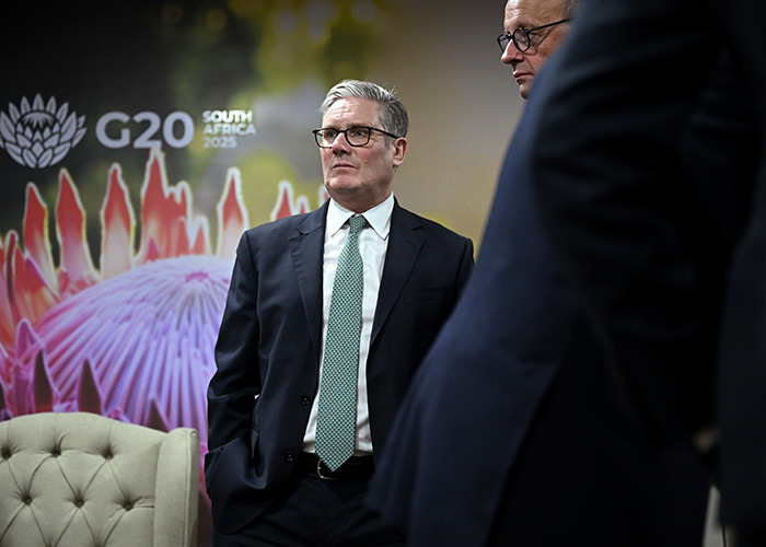 Man in suit and glasses at G20 summit, South Africa 2023, discussing energy policies as world leaders engage in talks. Man in suit and glasses at G20 summit, South Africa 2023, discussing energy policies as world leaders engage in talks.