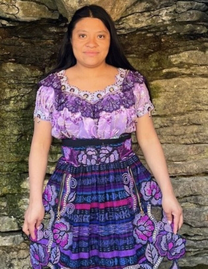 Woman in traditional purple dress standing against a stone wall related to Indiana man charged shooting house cleaner incident Woman in traditional purple dress standing against a stone wall related to Indiana man charged shooting house cleaner incident