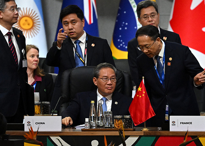 G20 leaders from China and France discussing new energy policies at an international summit with country flags visible. G20 leaders from China and France discussing new energy policies at an international summit with country flags visible.