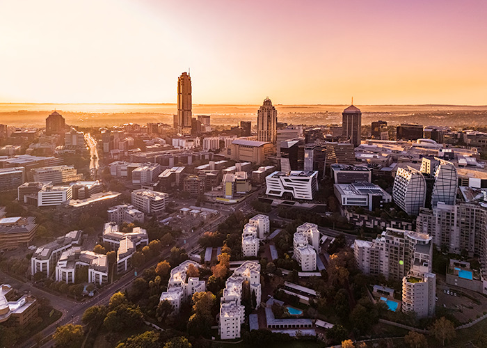 City skyline at sunset with modern buildings representing G20 powers advancing new energy initiatives. City skyline at sunset with modern buildings representing G20 powers advancing new energy initiatives.