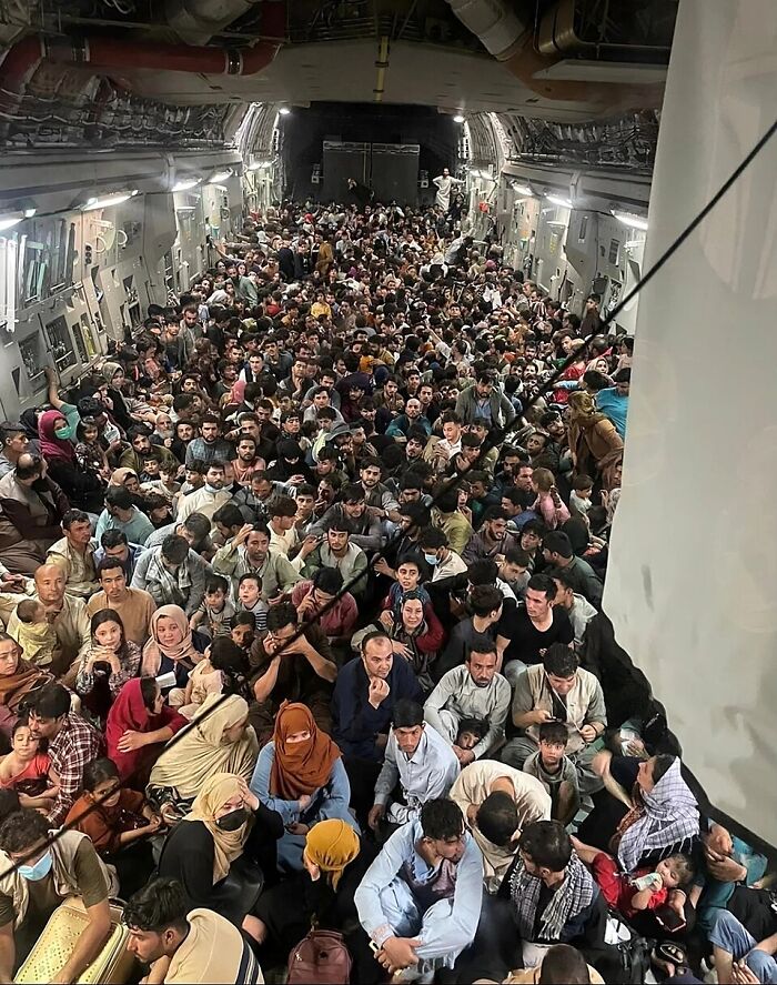 Large crowd of Afghan refugees inside a military aircraft during evacuation amid Afghan shooter exchange and Trump reporter insults. Large crowd of Afghan refugees inside a military aircraft during evacuation amid Afghan shooter exchange and Trump reporter insults.