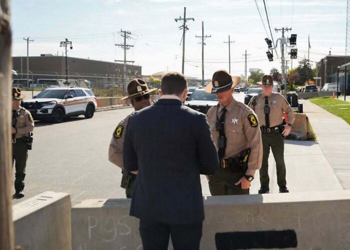Man in tears talking to ICE officers outside detention facility on a sunny day, surrounded by law enforcement vehicles. Man in tears talking to ICE officers outside detention facility on a sunny day, surrounded by law enforcement vehicles.