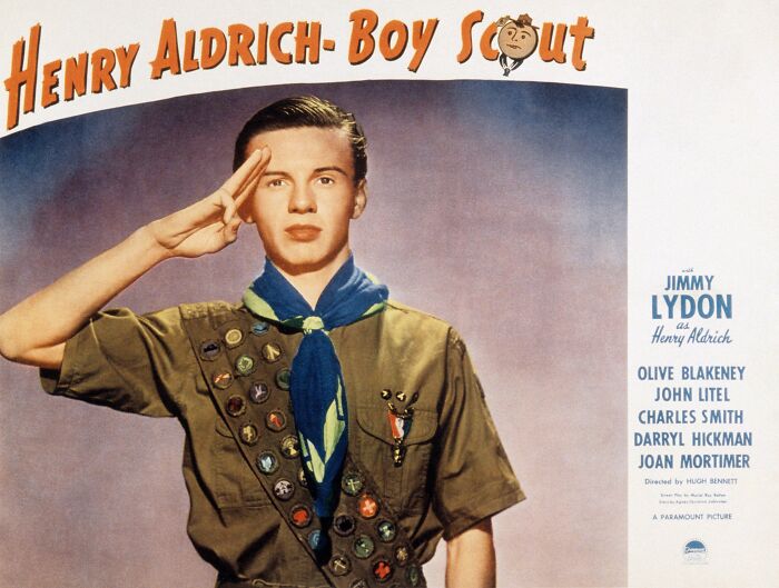 Young boy scout in uniform saluting, representing Boy Scouts amid discussions on genderless policies and planned tie cuts.