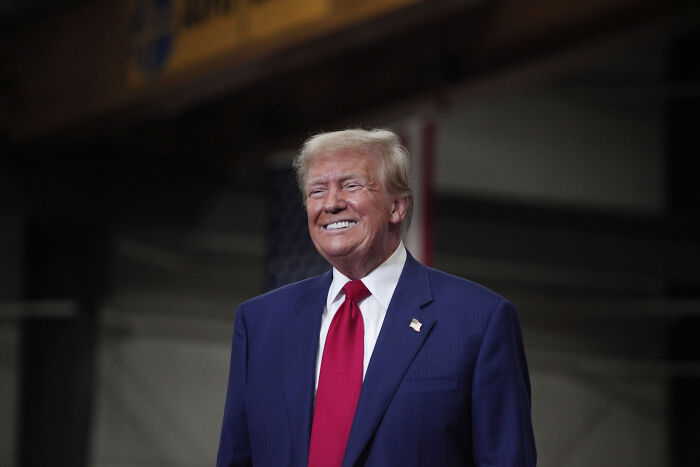 Former President Donald Trump smiling at an event, representing MAGA fans discussing rising food costs online.