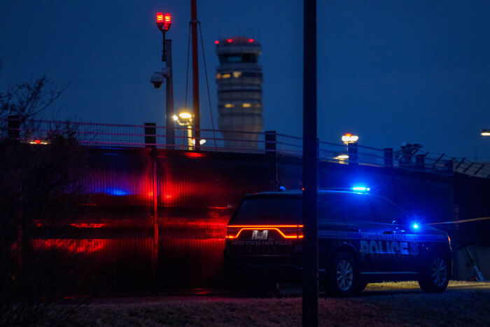 Police vehicle with flashing lights parked near a fence at night, related to parents jailed after 9-day-old baby incident. Police vehicle with flashing lights parked near a fence at night, related to parents jailed after 9-day-old baby incident.