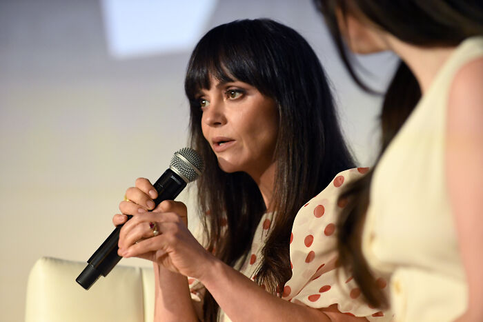 Christina Ricci speaking into microphone at panel discussion, addressing controversy involving Megyn Kelly and Epstein comments. Christina Ricci speaking into microphone at panel discussion, addressing controversy involving Megyn Kelly and Epstein comments.