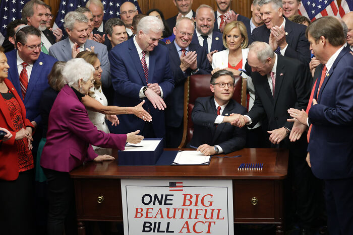 Group of politicians gathered around desk with One Big Beautiful Bill Act sign, illustrating ex-Trump fans losing hope in 2025. Group of politicians gathered around desk with One Big Beautiful Bill Act sign, illustrating ex-Trump fans losing hope in 2025.