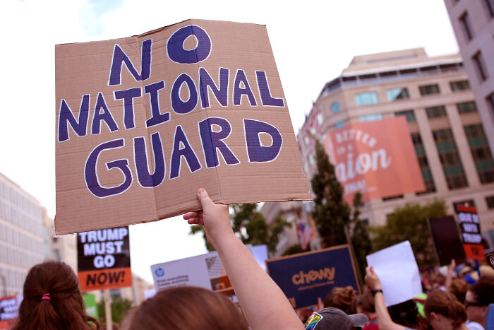 Protesters in Washington holding signs including one saying no National Guard against Trump National Guard orders. Protesters in Washington holding signs including one saying no National Guard against Trump National Guard orders.