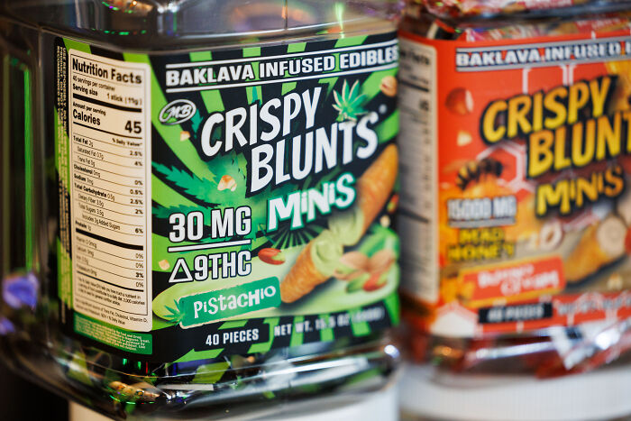 Container of Crispy Blunts mini edibles with THC, highlighting products linked to people crushed by government actions. Container of Crispy Blunts mini edibles with THC, highlighting products linked to people crushed by government actions.