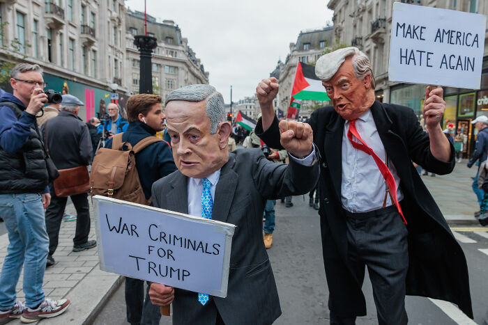 Protesters wearing political masks hold signs criticizing Trump, reflecting ex-Trump fans losing hope in 2025. Protesters wearing political masks hold signs criticizing Trump, reflecting ex-Trump fans losing hope in 2025.