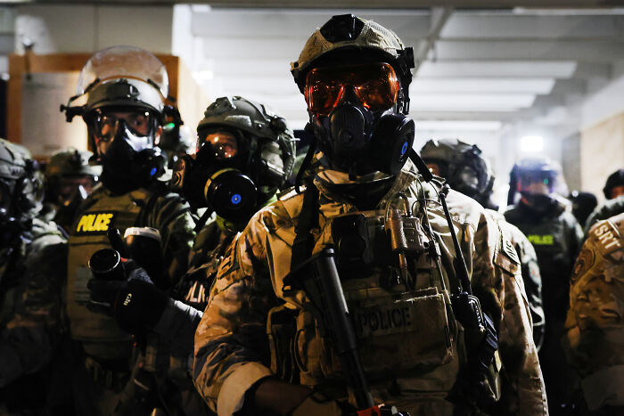 Law enforcement officers in tactical gear and gas masks preparing for ICE raids during a MAGA fan viral incident. Law enforcement officers in tactical gear and gas masks preparing for ICE raids during a MAGA fan viral incident.