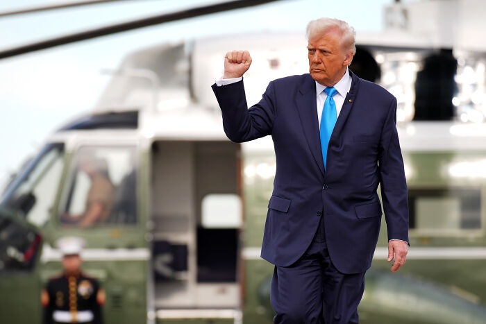 Former President Trump raising fist near helicopter, amid Swifties outrage over music use and lyric changes by Team Trump. Former President Trump raising fist near helicopter, amid Swifties outrage over music use and lyric changes by Team Trump.