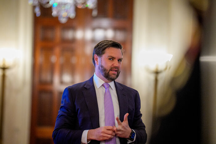 Man in suit and purple tie speaking indoors with wooden doors behind, related to Trump comments on JD Vance social media reaction Man in suit and purple tie speaking indoors with wooden doors behind, related to Trump comments on JD Vance social media reaction