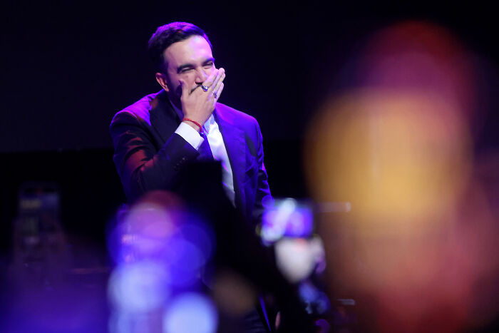 Zohran Mamdani in a dark suit delivers NYC mayoral victory speech, pledging to turn the volume up in political battle. Zohran Mamdani in a dark suit delivers NYC mayoral victory speech, pledging to turn the volume up in political battle.