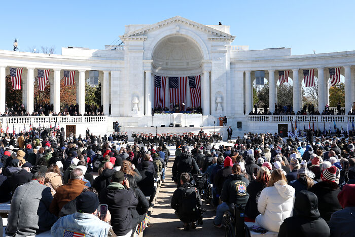 Large crowd gathered at a memorial event honoring fallen heroes with American flags, reflecting Veterans Day tribute and Russian twist. Large crowd gathered at a memorial event honoring fallen heroes with American flags, reflecting Veterans Day tribute and Russian twist.