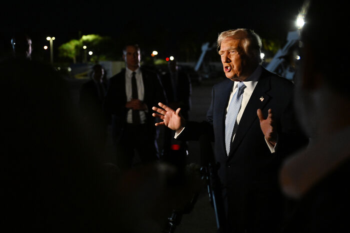 Donald Trump speaking urgently at night with security and press in the background, reacting to questions on Epstein files. Donald Trump speaking urgently at night with security and press in the background, reacting to questions on Epstein files.