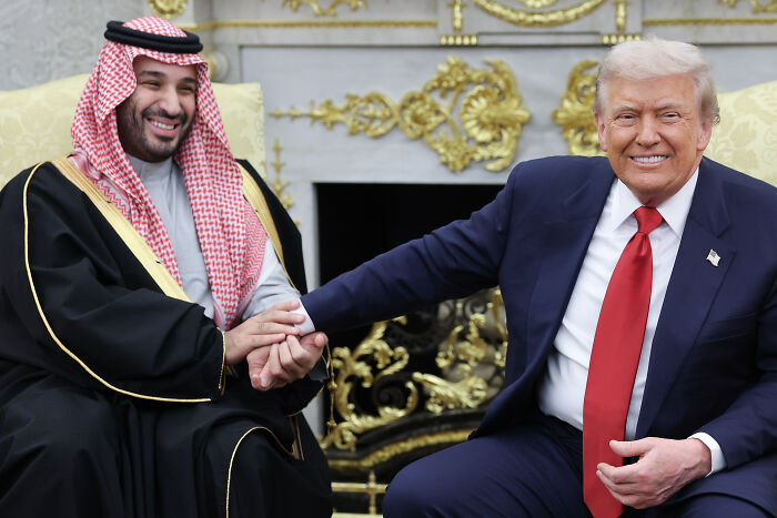 Donald Trump shaking hands with Saudi prince in formal setting amid Khashoggi controversy and defense statements. Donald Trump shaking hands with Saudi prince in formal setting amid Khashoggi controversy and defense statements.
